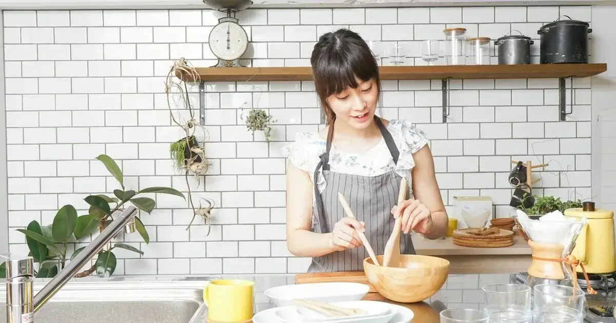 A person enjoying the process of cooking with ergonomic Kore Kitchen utensils.
