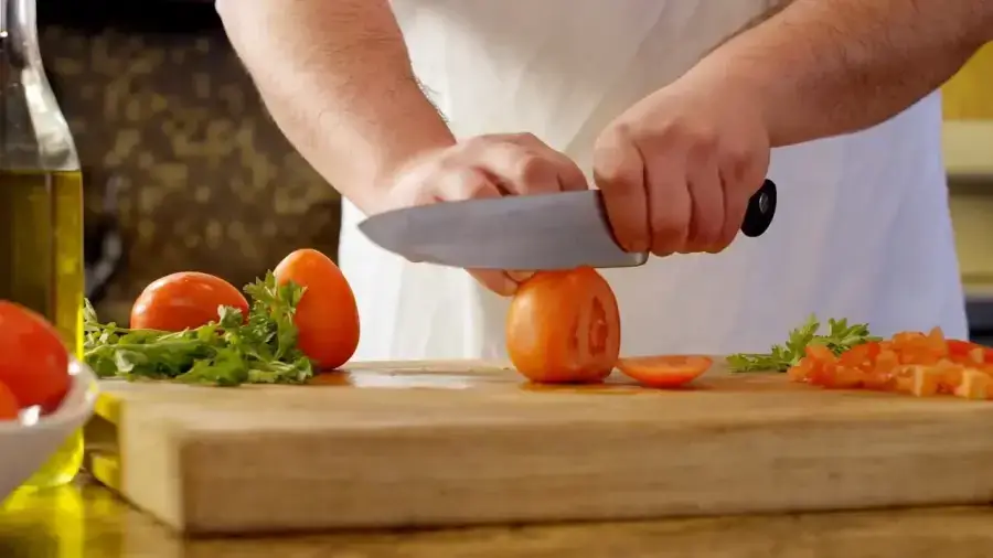 Close-up of a chef meticulously preparing food with a high-quality knife.