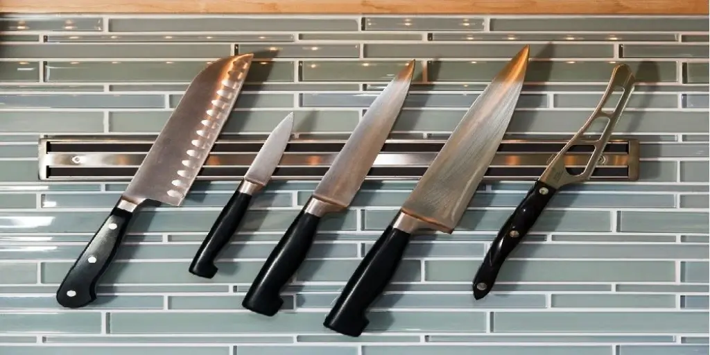 A customer inspecting a Kore Kitchen knife in a premium retail environment.