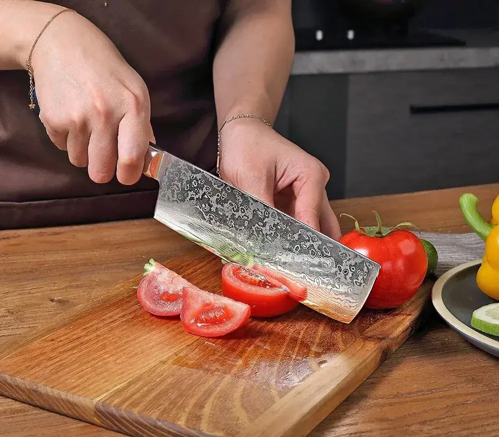 Close-up of a Kore Kitchen knife slicing vegetables with precision.