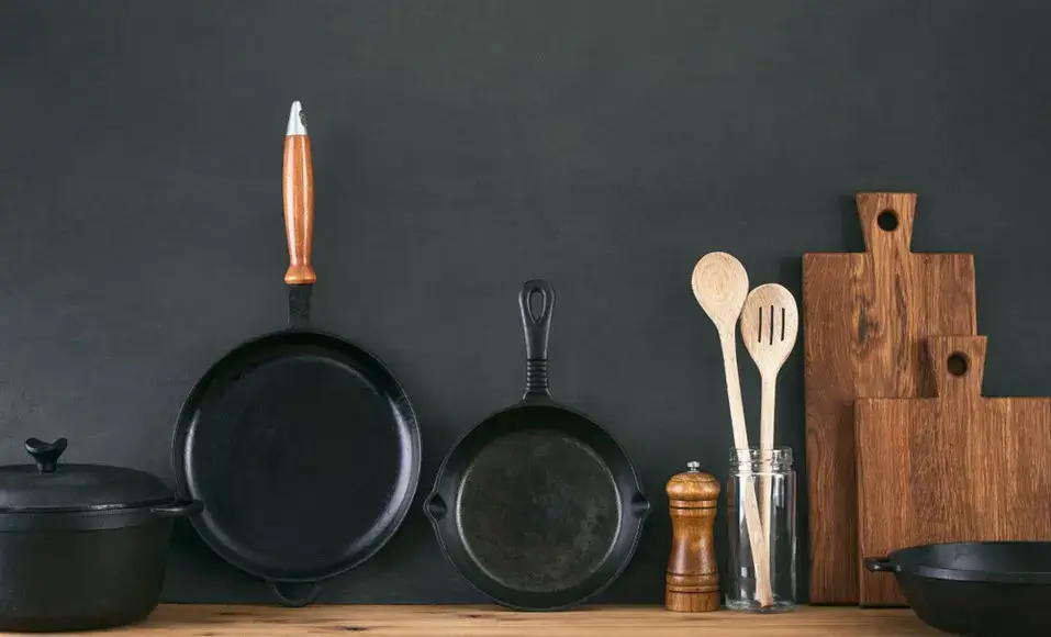 A chef's hand running over a smooth, high-quality wooden handle of a kitchen utensil.